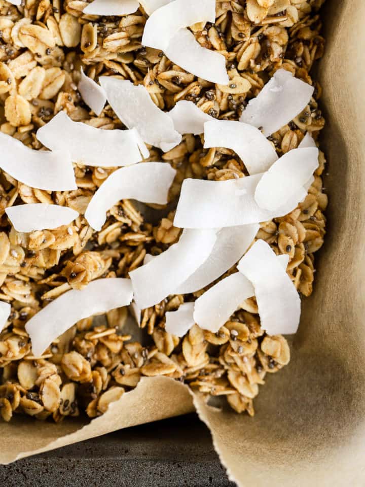 Simple coconut chia granola on parchment paper lined sheet pan