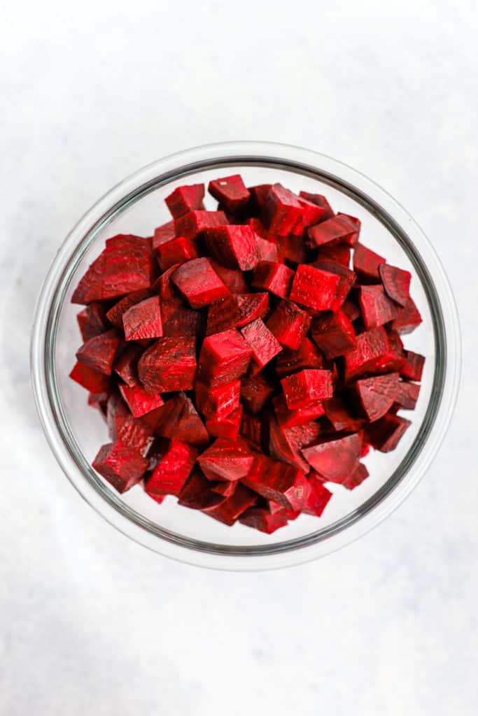 Beets peeled and cubed in clear glass bowl.