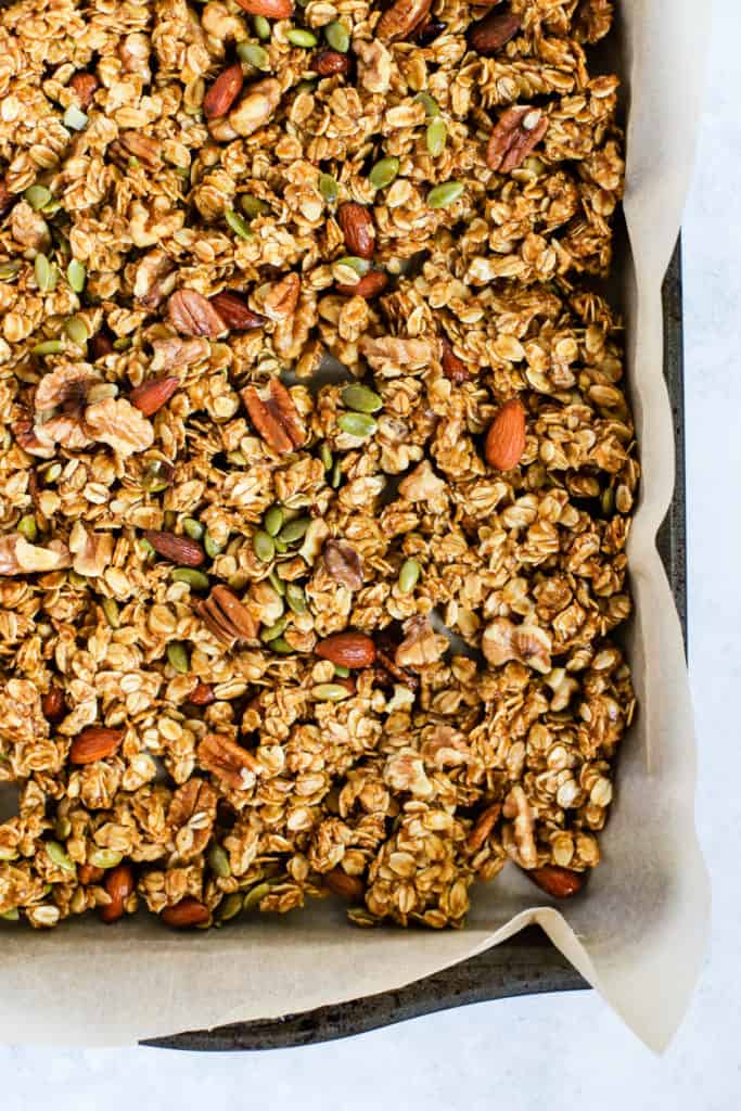 Healthy pumpkin granola in parchment paper-lined sheet pan