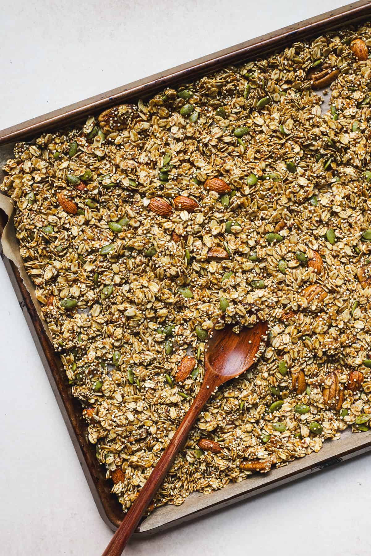 Pumpkin granola being spread into sheet pan.
