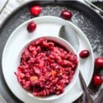 Cranberry relish in small white bowl with spoon.