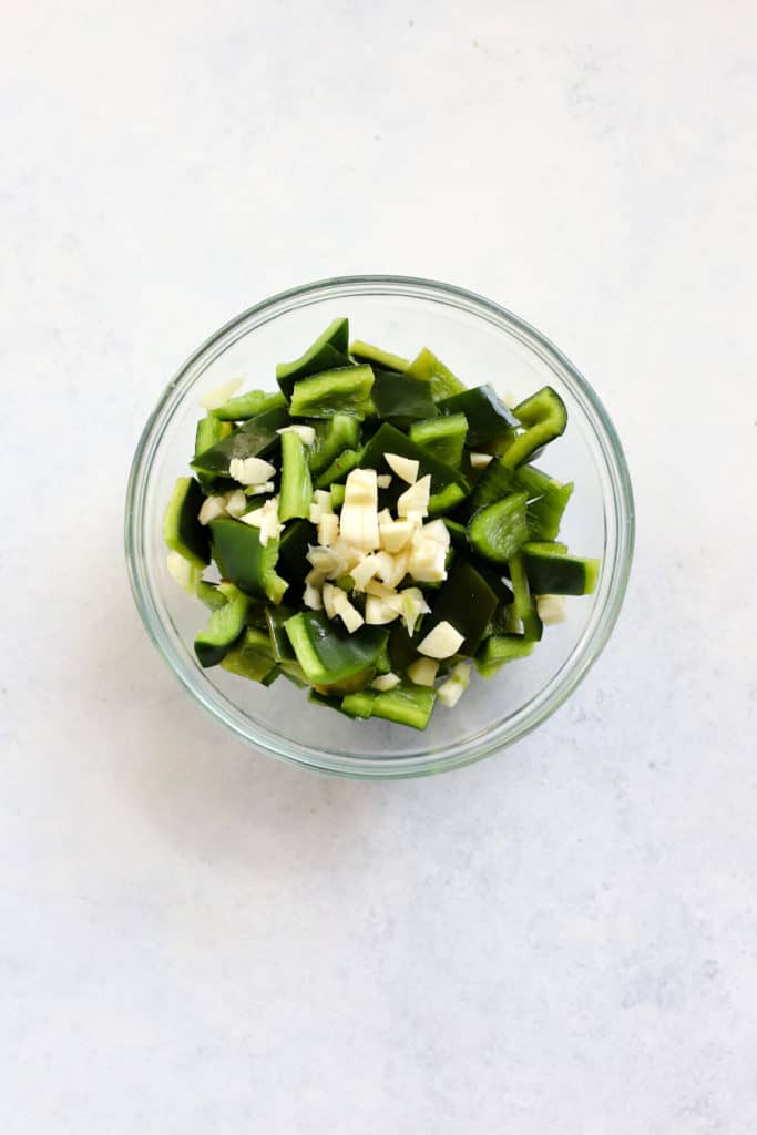 Diced poblano peppers and minced garlic in small glass dish