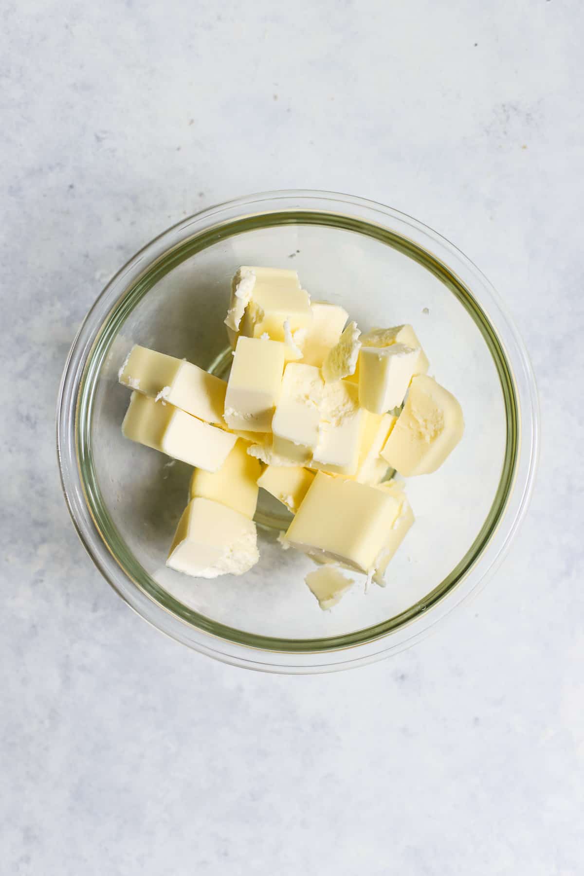 Cold butter cubes in clear glass bowl.