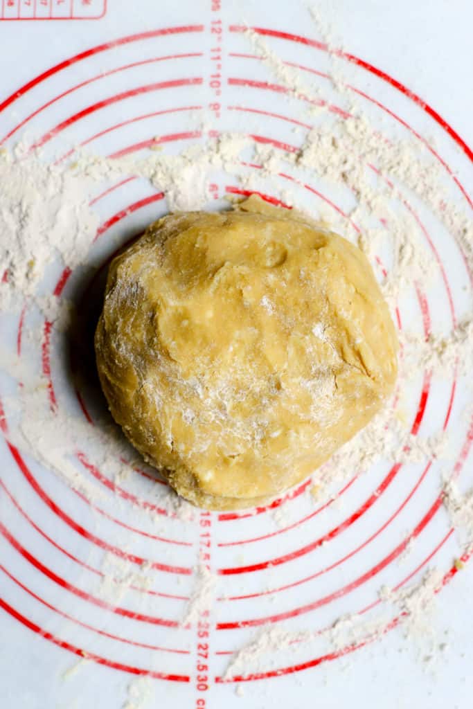 Chickpea flour pie dough disc on floured pastry mat