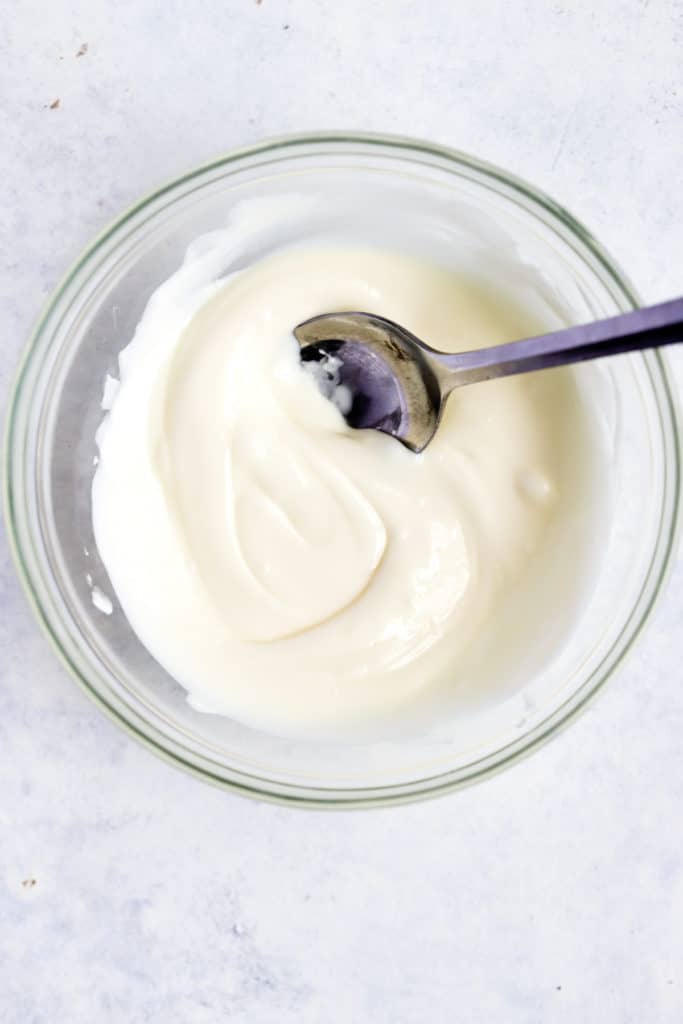 Melted white chocolate chips in small glass bowl