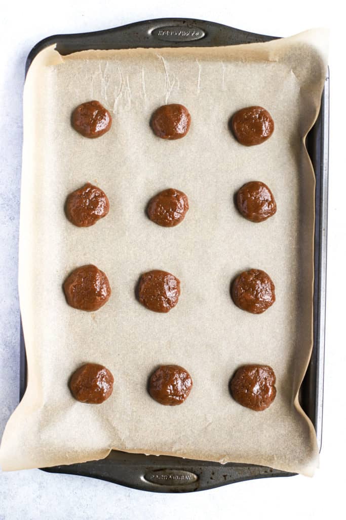 Cookie dough balls on parchment-lined baking sheet