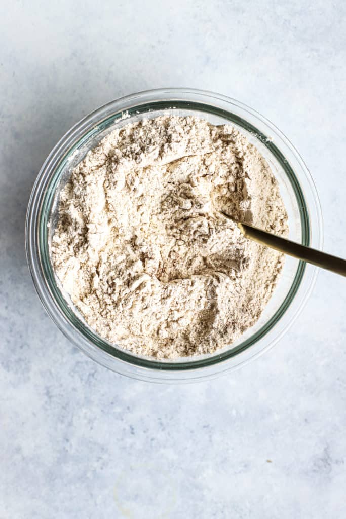 Dry ingredients for healthier ginger molasses cookies, whisked together in clear glass bowl