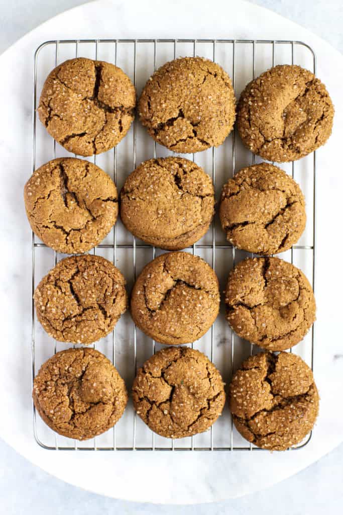 Fully baked and cooled, healthier soft ginger molasses cookies in cooling rack, on white marble lazy susan