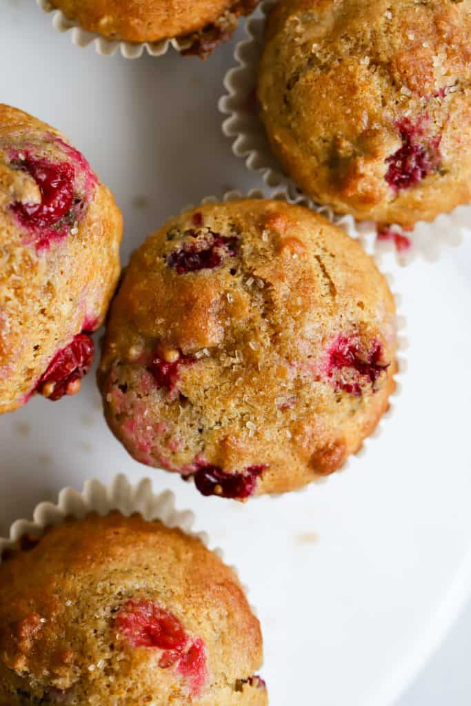 Healthy cranberry orange muffins on white marble cake stand