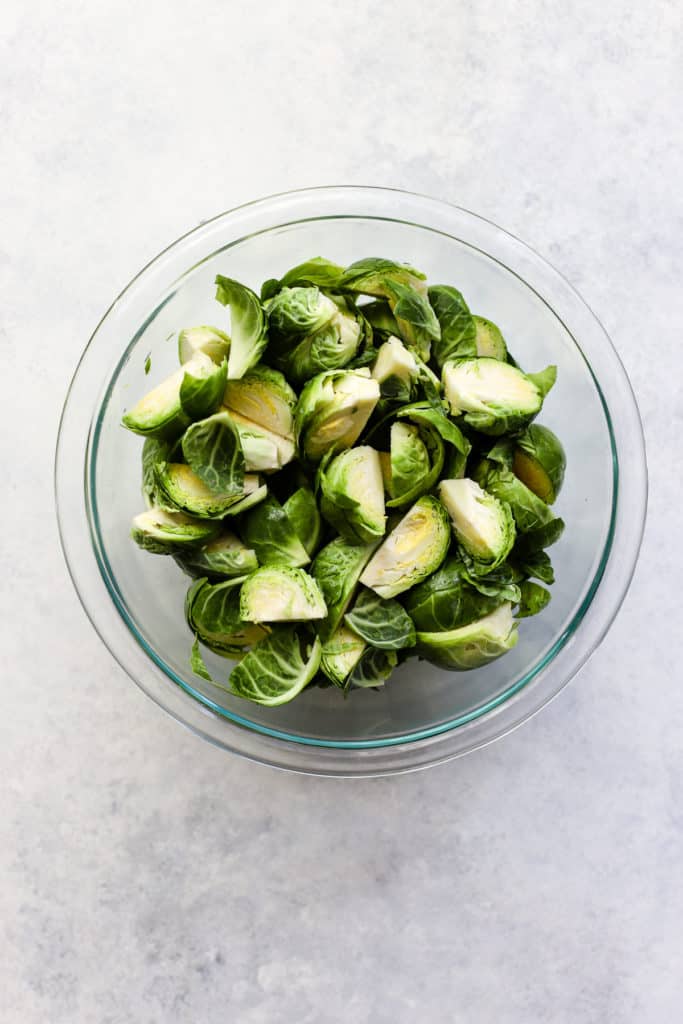 Quartered Brussels sprouts in clear glass bowl