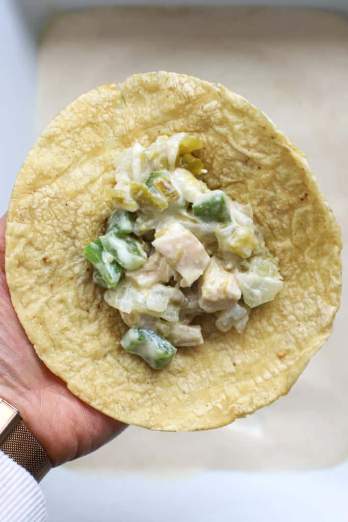 Corn tortilla with scoop of chicken enchilada filling.