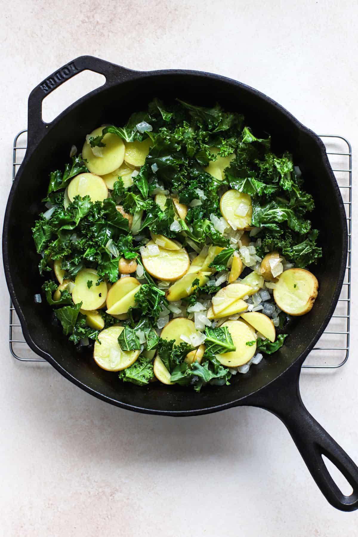 Thinly sliced Yukon gold potatoes, kale, and diced onions sautéed in a black cast iron skillet.