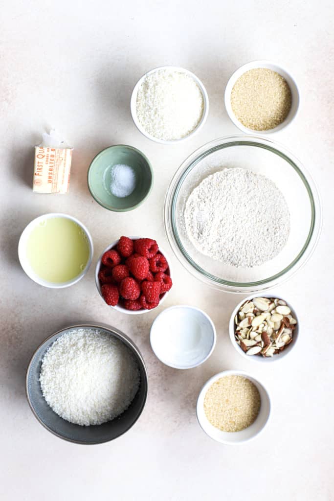 Raspberry almond macaroon tart ingredients on white-beige surface