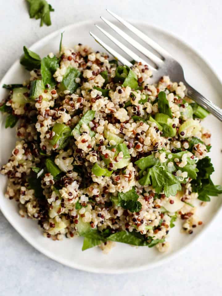 Simple detox quinoa salad on small white plate with fork