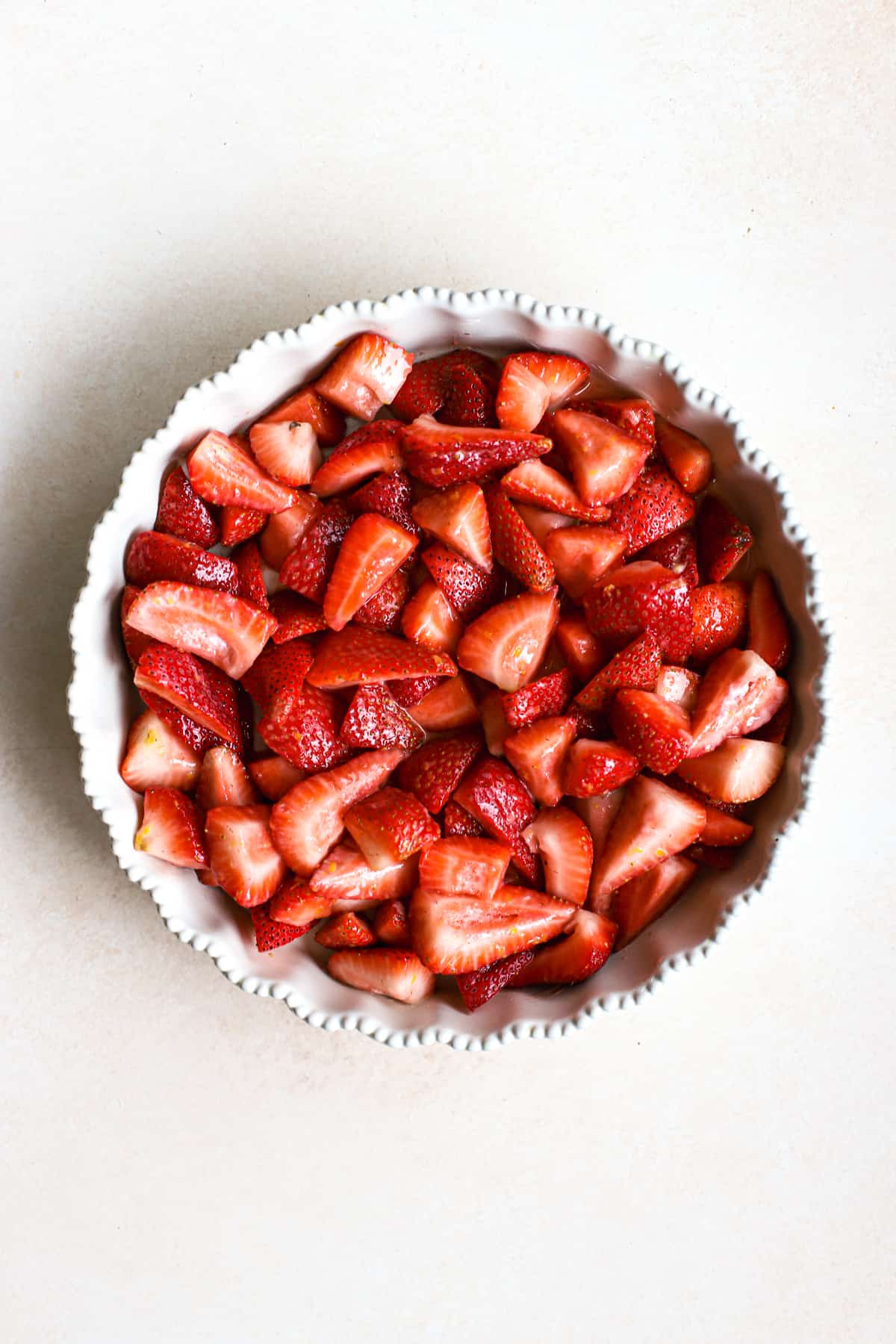 Fresh strawberry filling in a ceramic baking dish for strawberry crisp.