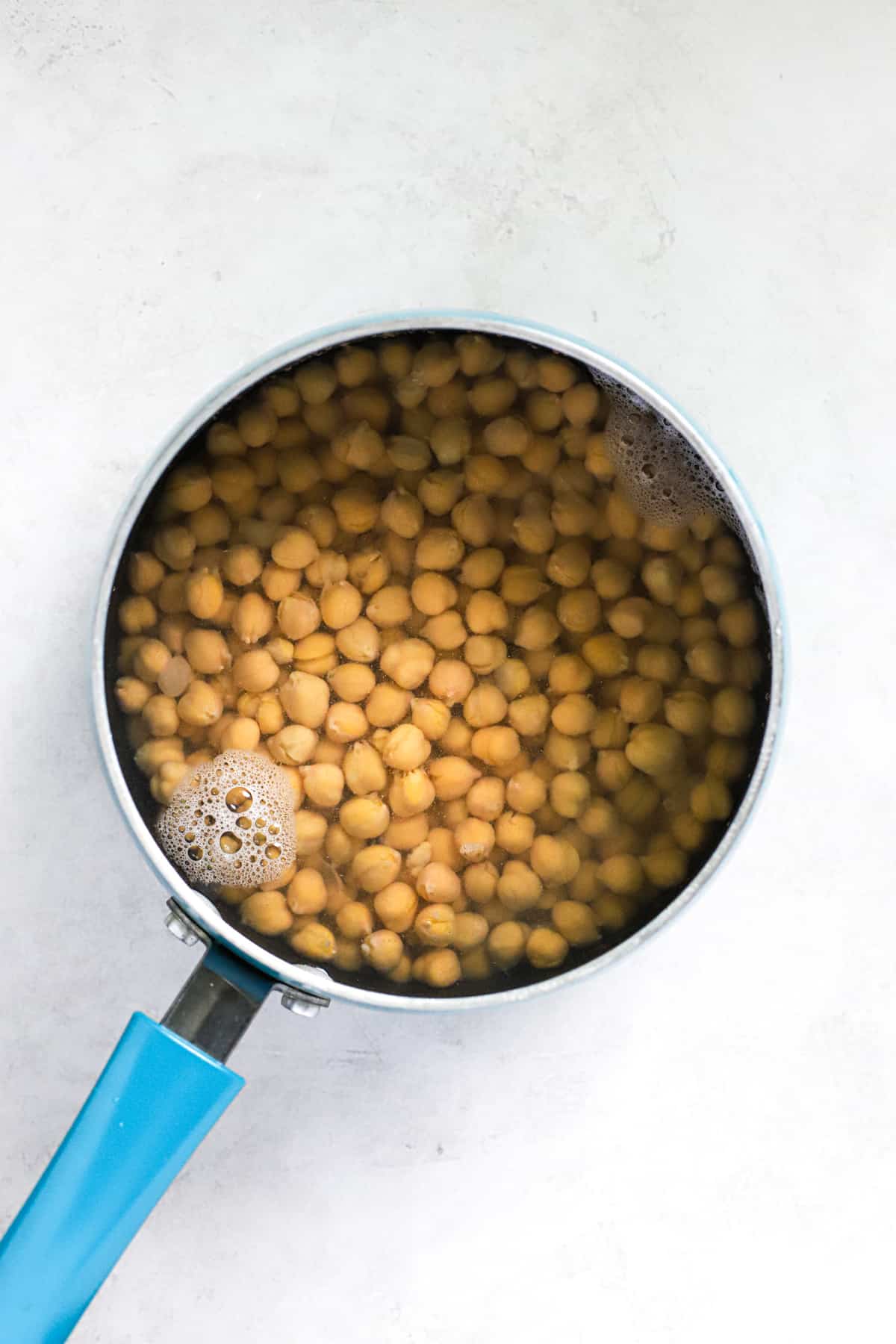 Chickpeas and baking soda in small blue pot.