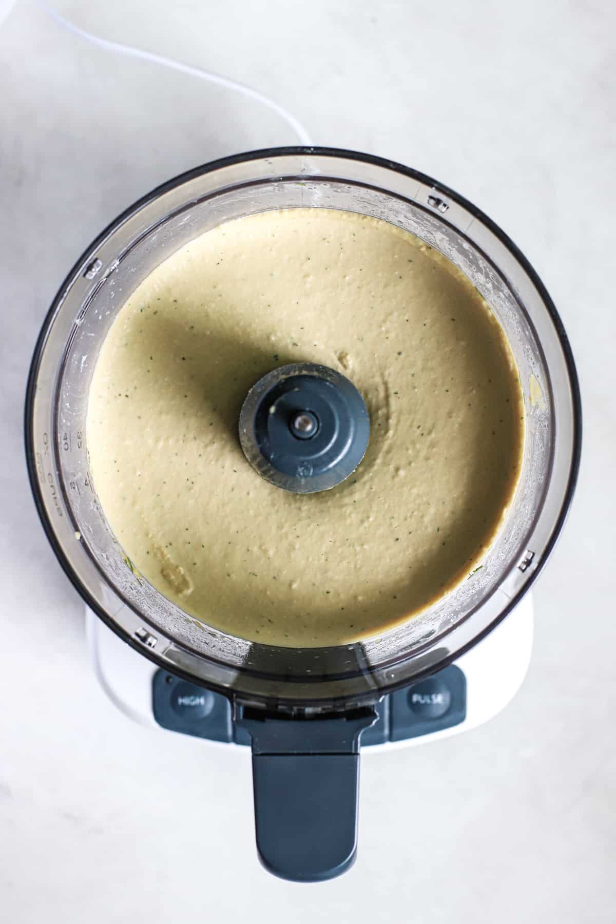 Lemon dill hummus blended together in food processor.