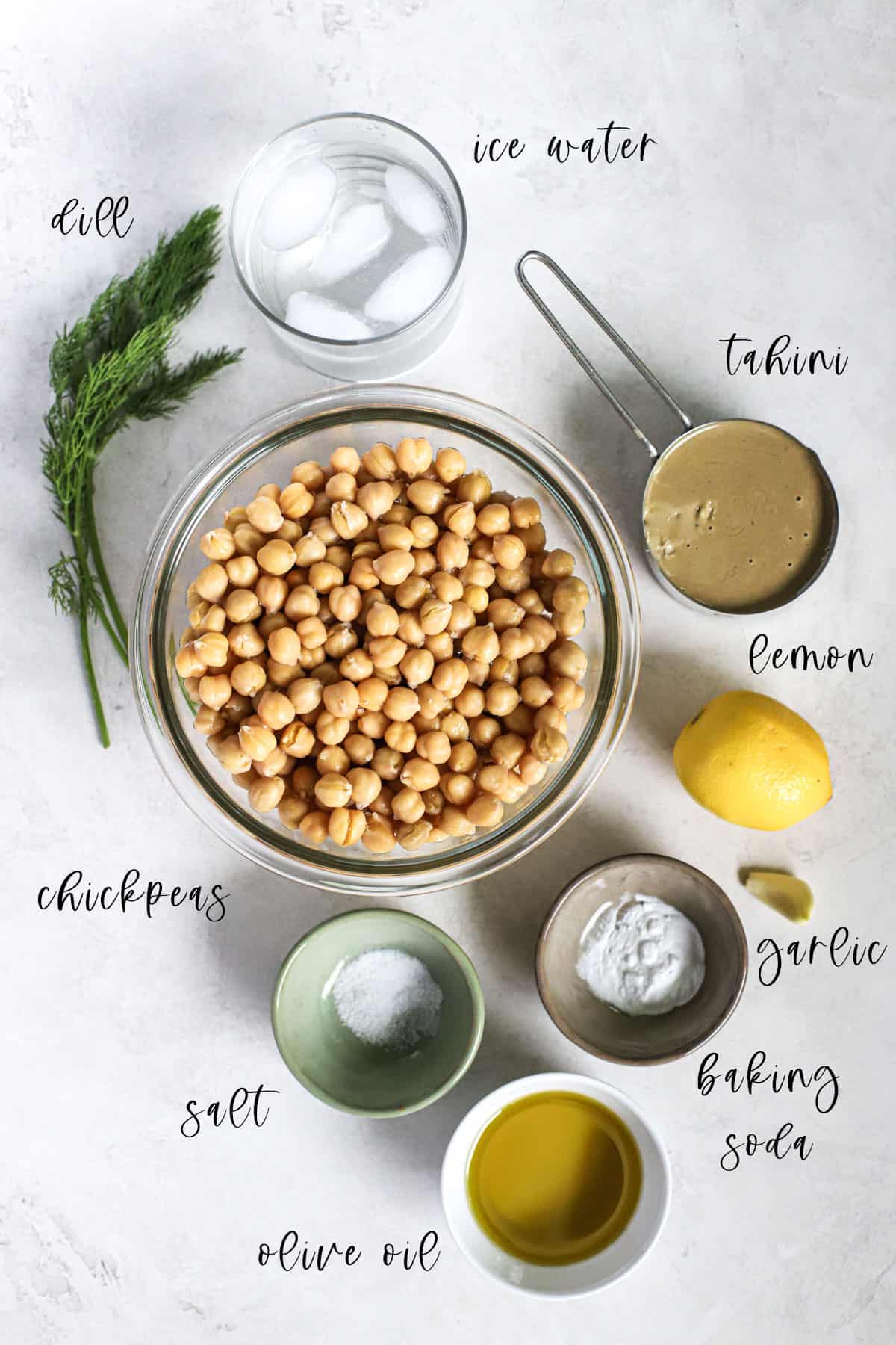 Lemon dill hummus ingredients on gray and white surface.