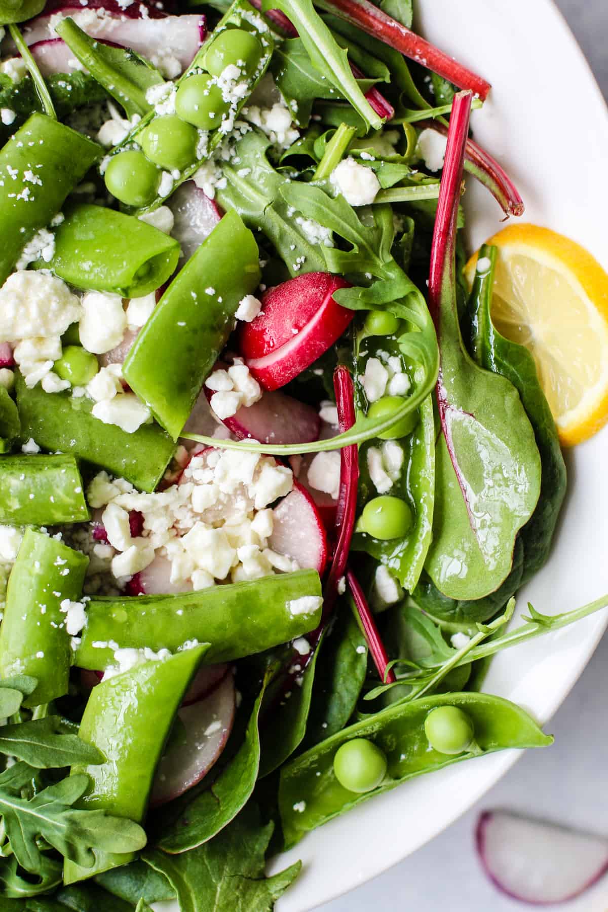 spring pea and radish salad in white serving bowl