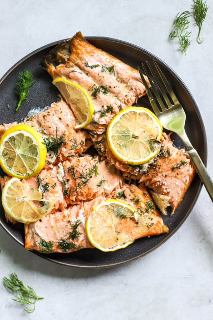 Lemon dill salmon topped with lemon slices on a plate.