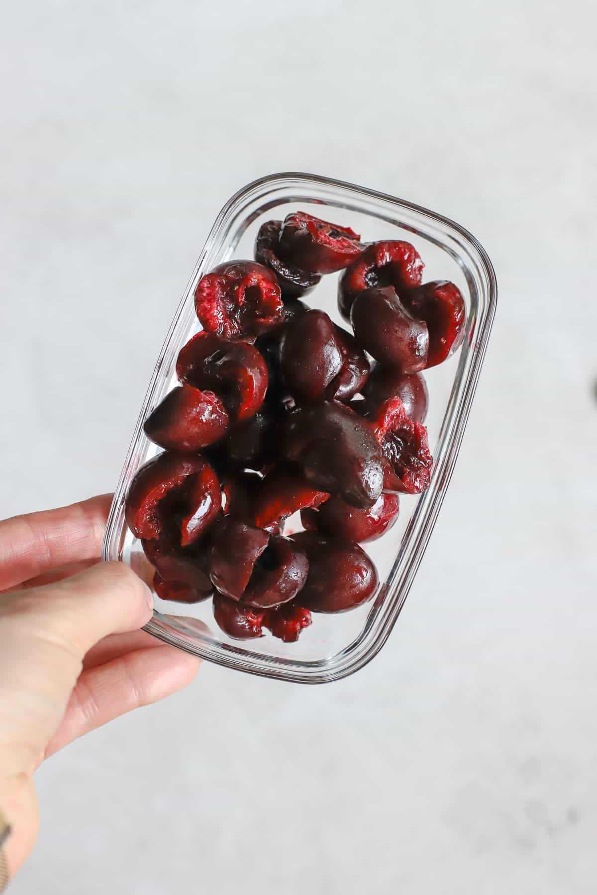 Pitted sweet cherries in rectangular glass container.