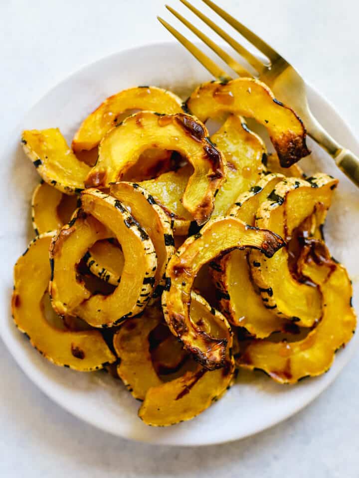 Air-fried delicata squash on white plate with golden fork