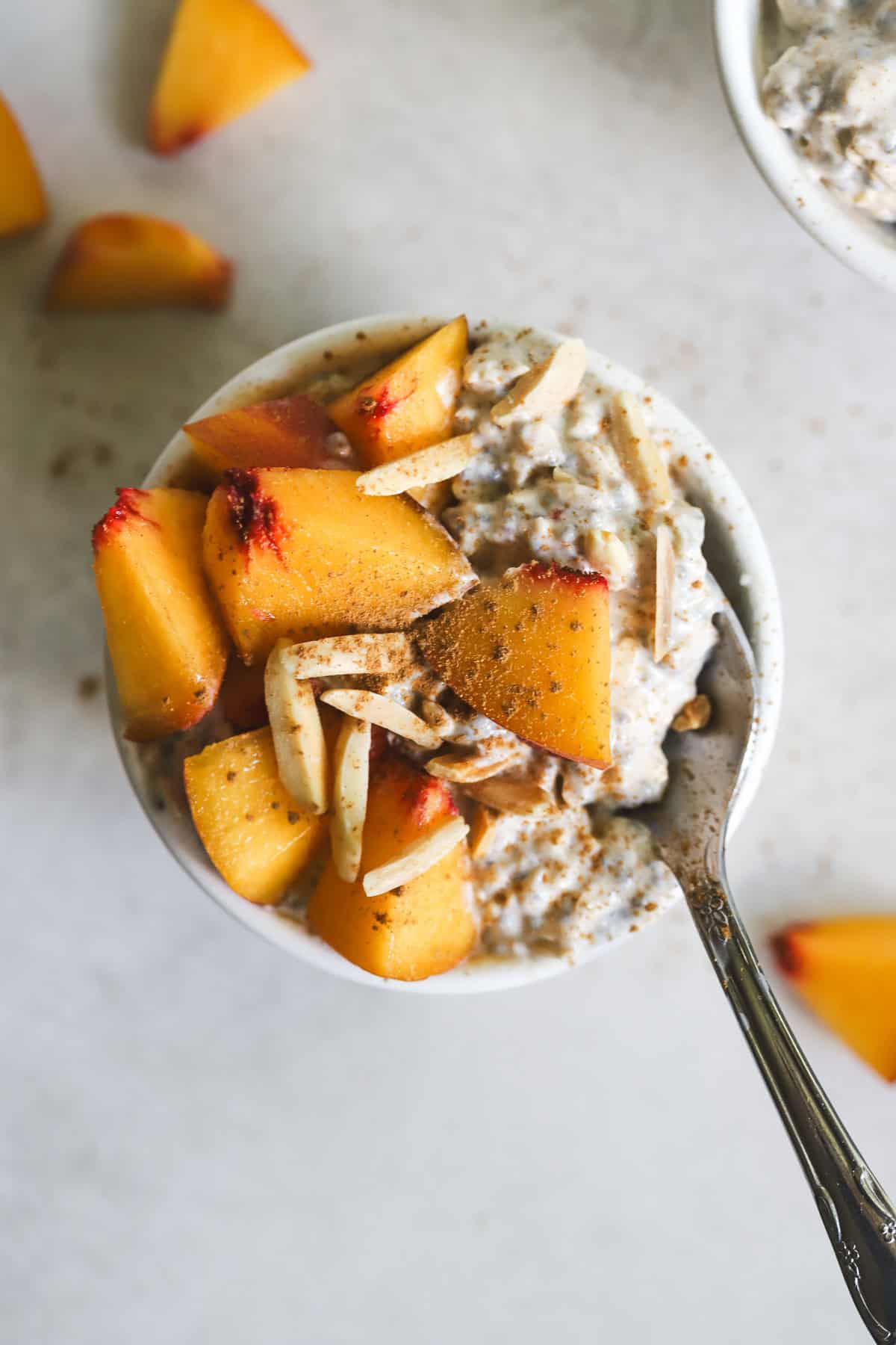 Peach pie overnight oats in small white bowl.
