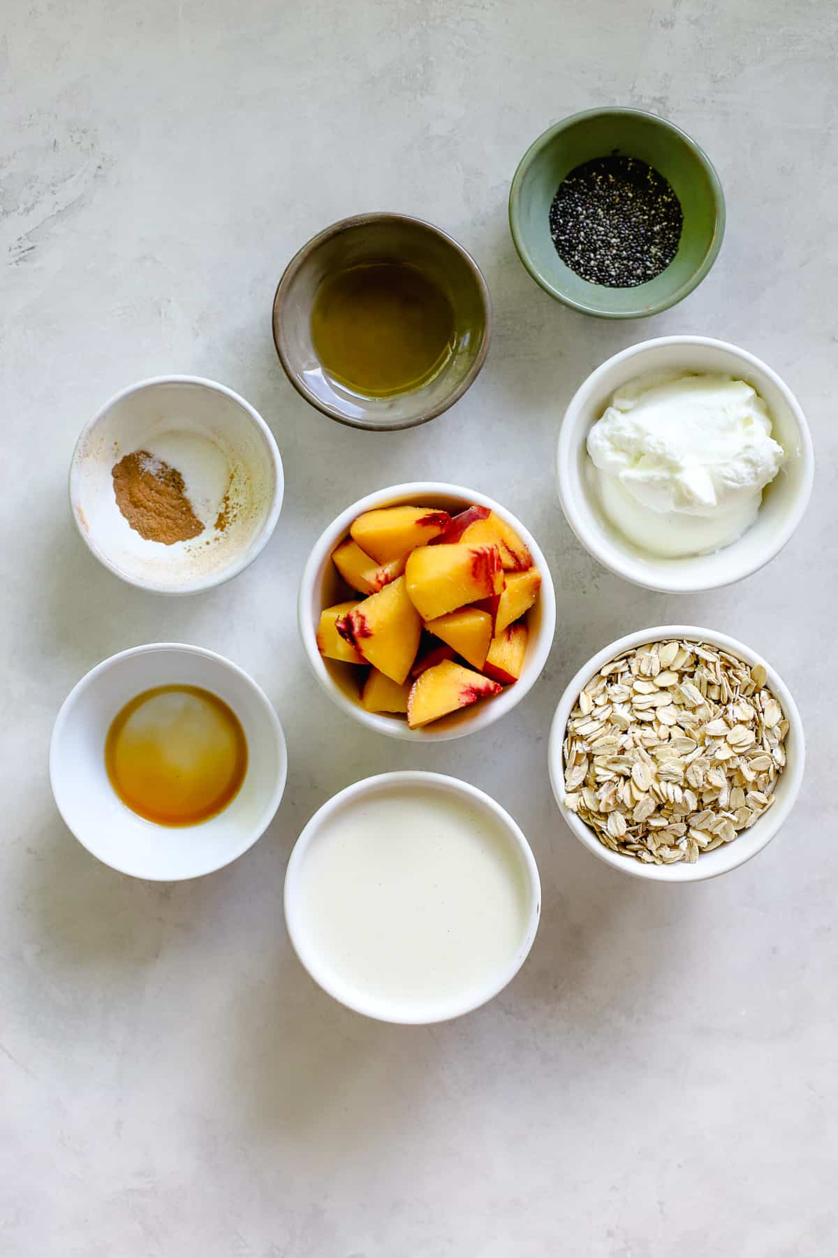 Peach pie overnight oats ingredients on light gray surface