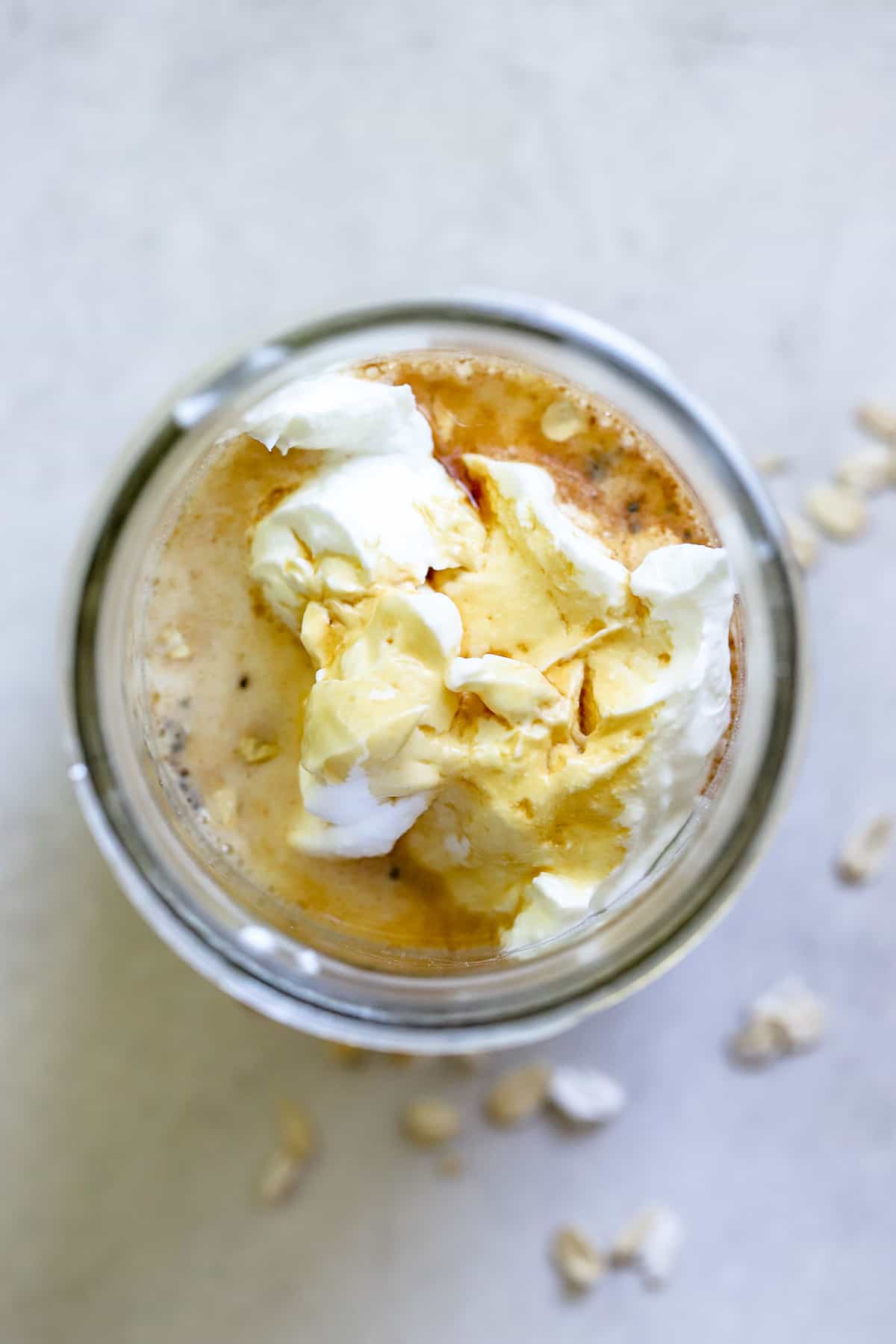 Addition of Greek yogurt, maple syrup, vanilla extract, and milk to jar of oats