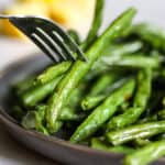 Air fryer green beans being speared with a fork