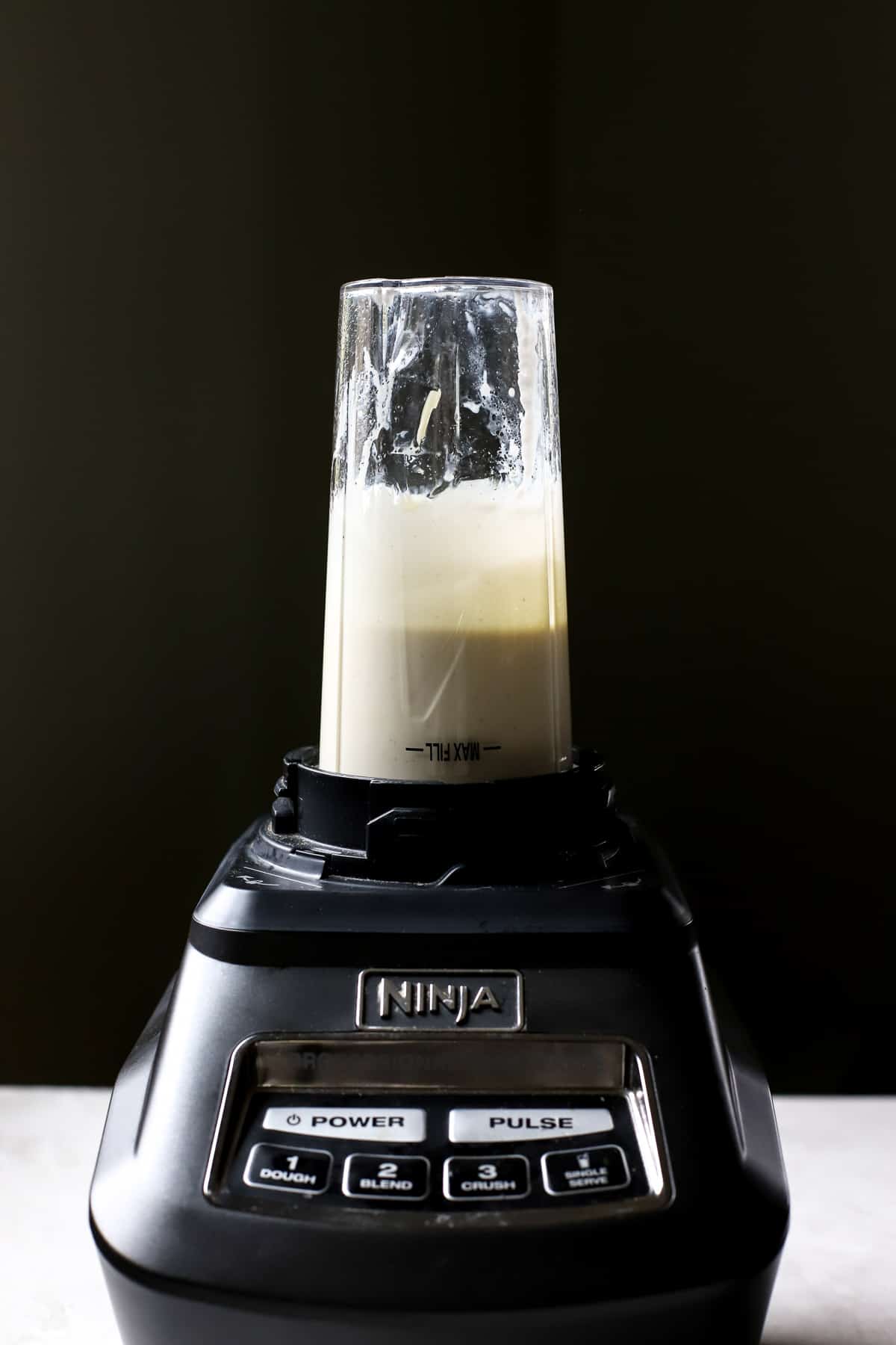 Dressing ingredients fully blended in a black Ninja blender using the single size blending cup.