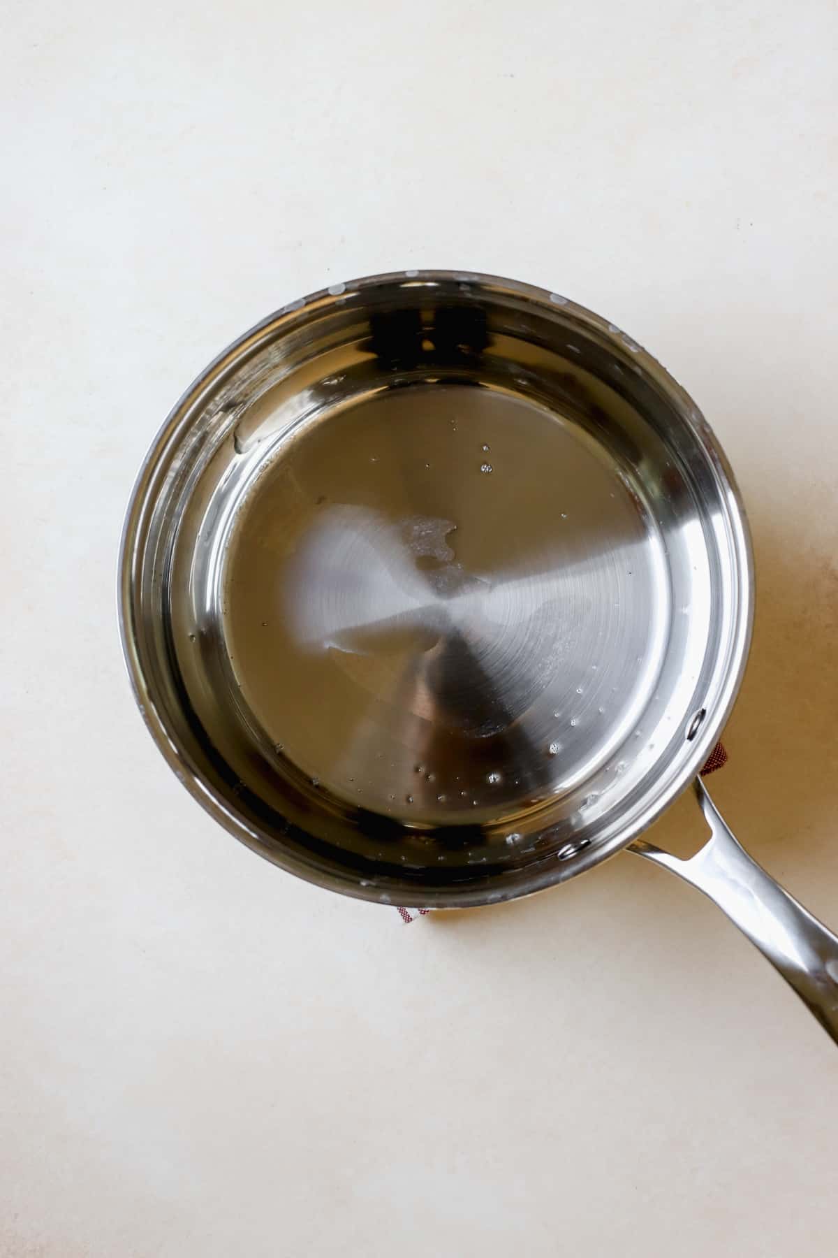 Coconut oil heating up in medium-sized stainless steel saucepan