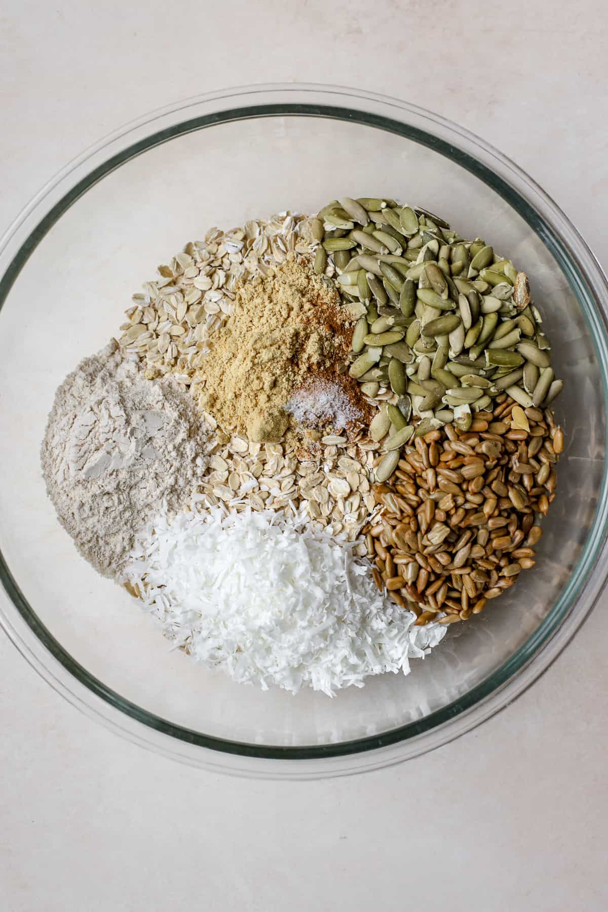 Dry granola ingredients in clear glass bowl