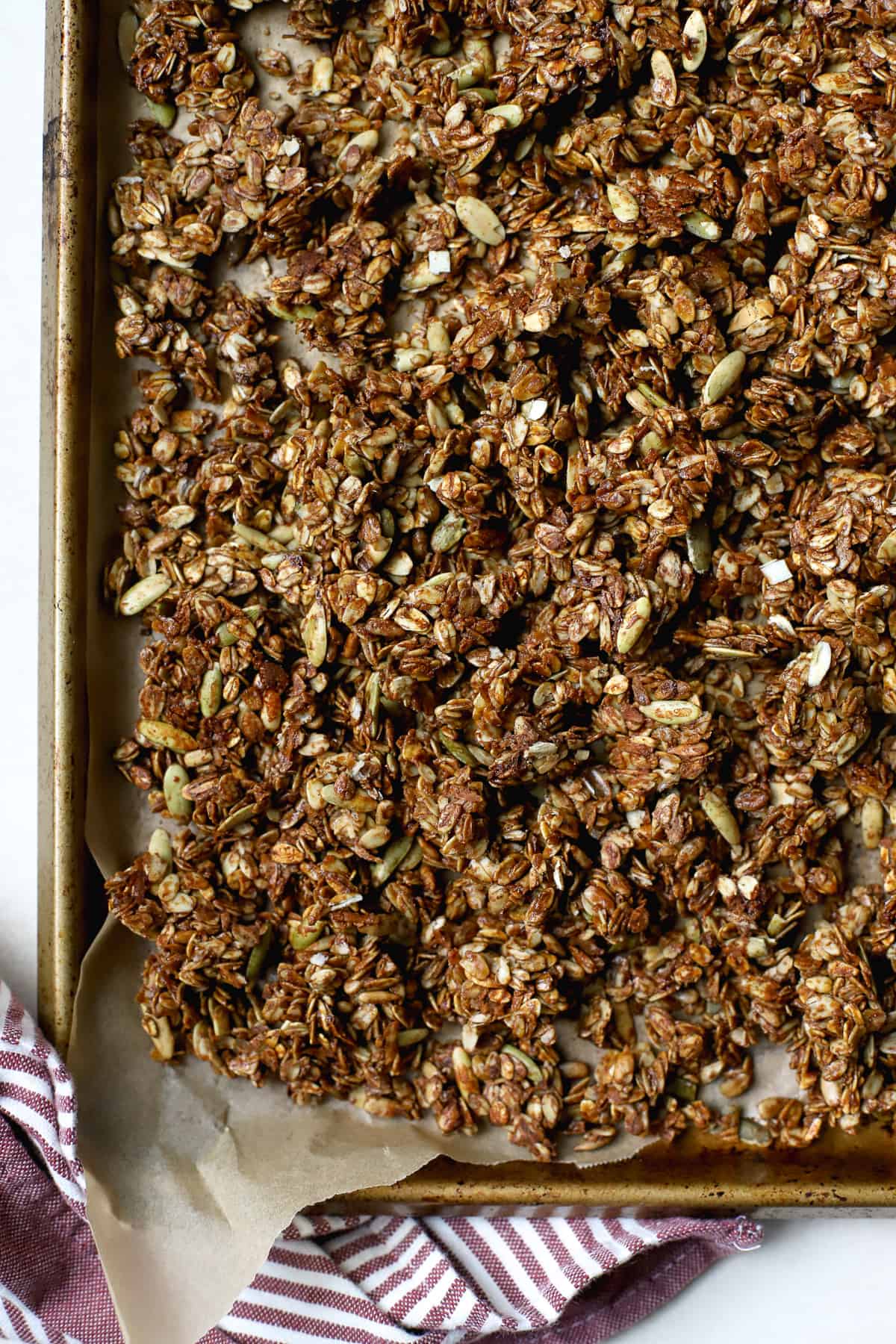 Ginger molasses granola crumbled on sheet pan lined with parchment paper