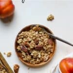 Maple pecan granola on small acacia plate with spoon.