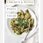 Chicken pesto pasta salad on a white plate with fork.