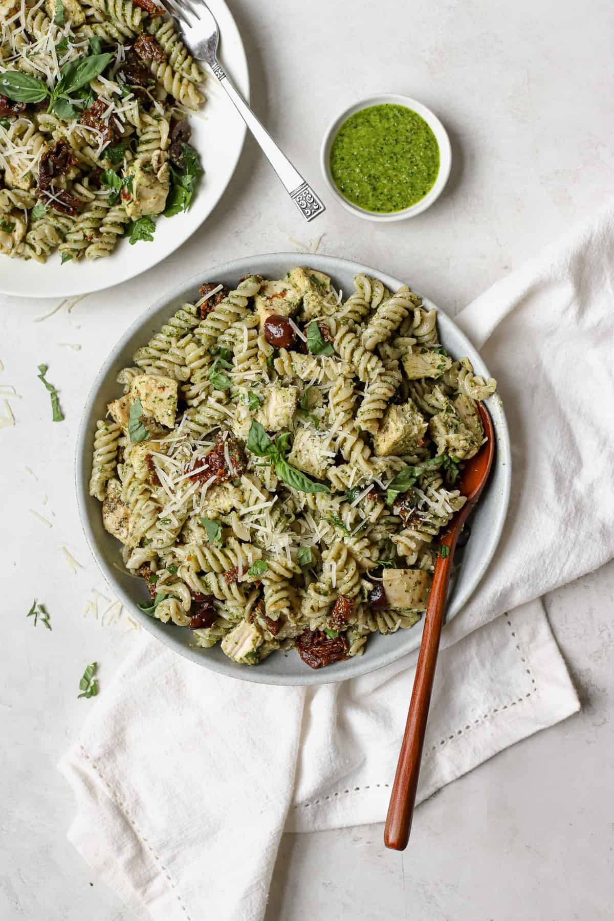 Chicken pesto pasta salad in a light blue serving bowl.