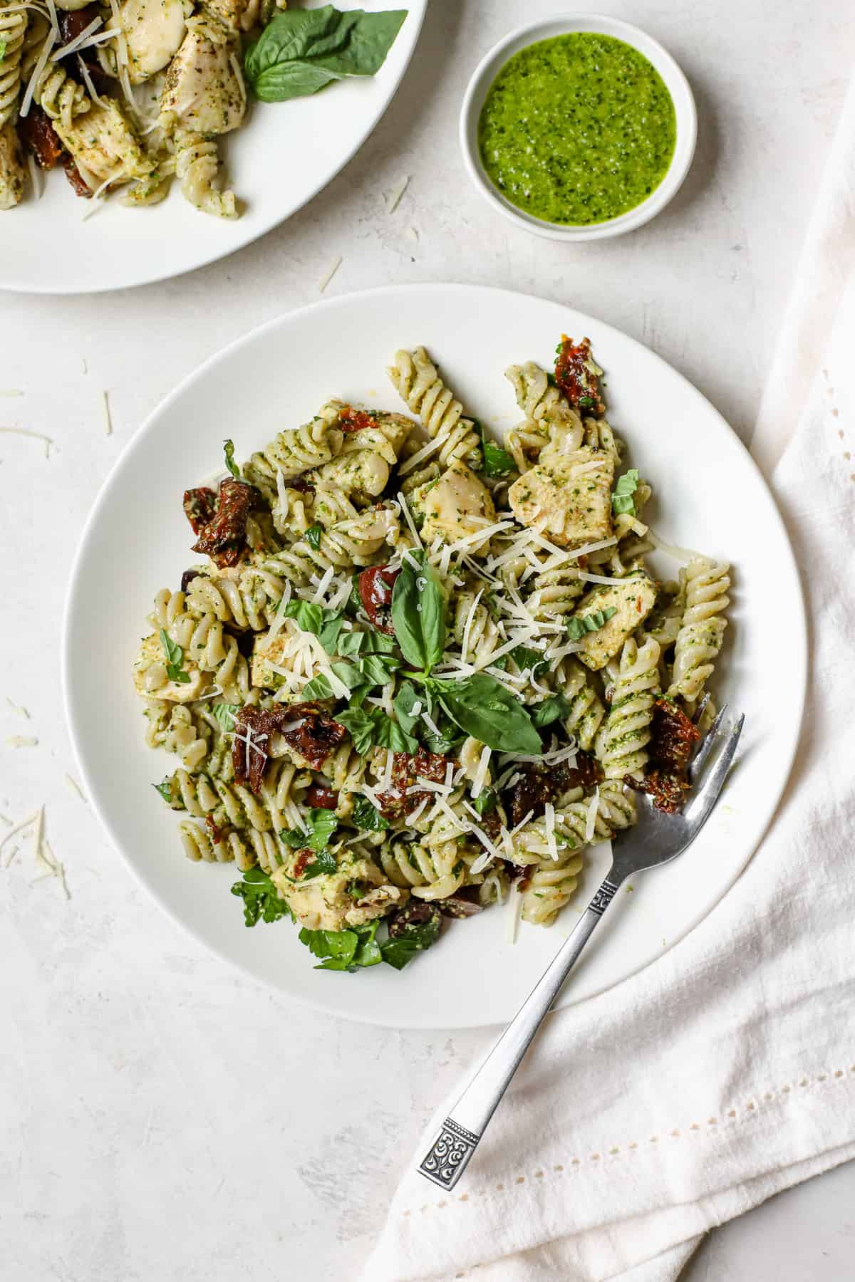 Chicken pesto pasta salad on a white plate.