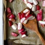 Roasted radishes on sheet pan with wooden spatula.