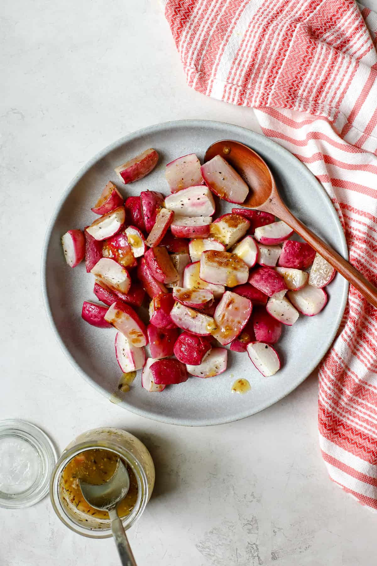 Roasted radishes tossed with vinaigrette in blue bowl.