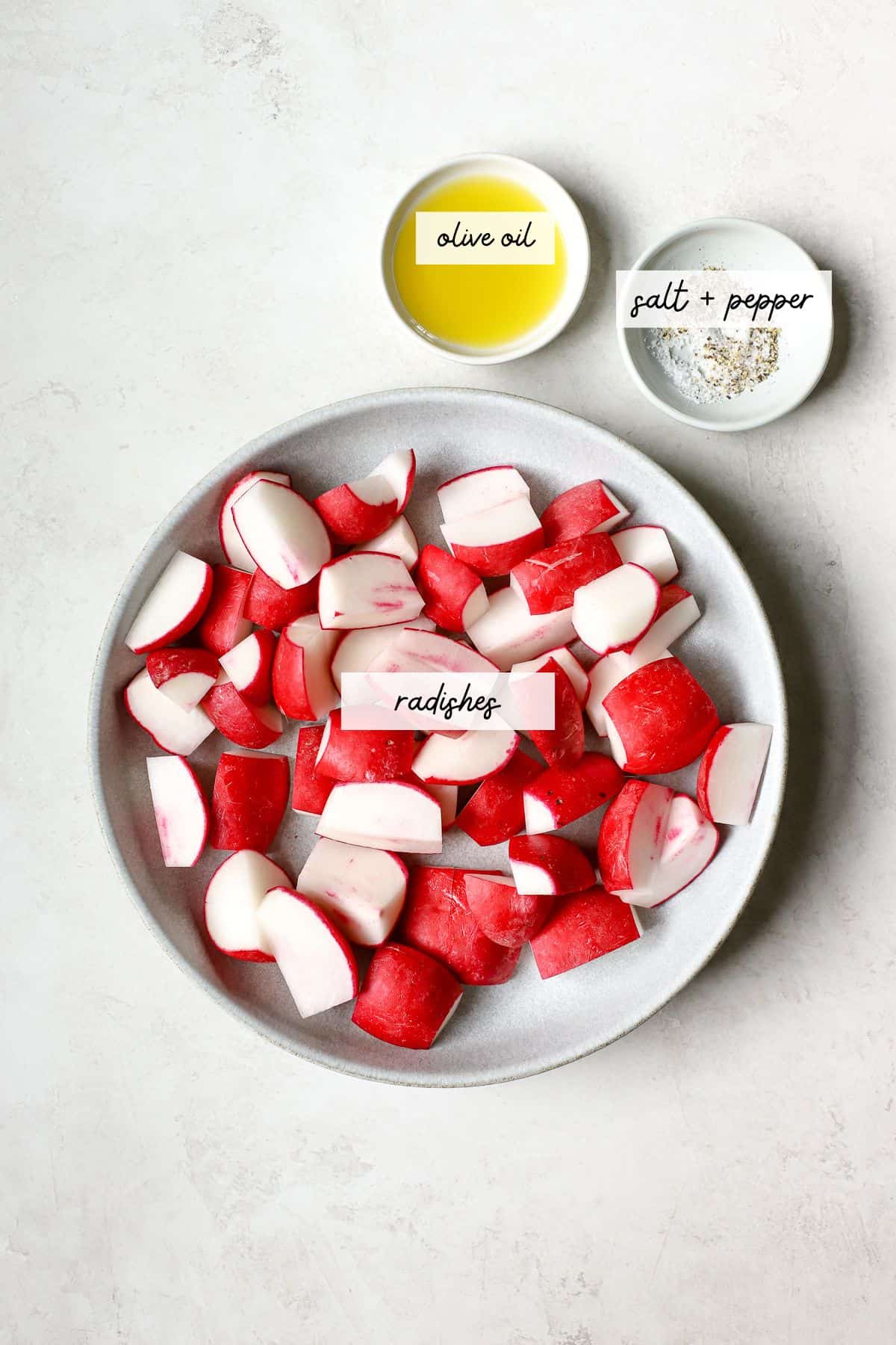 Radishes, olive oil, salt, and pepper in bowls.