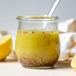 Simple lemon vinaigrette in small jar.