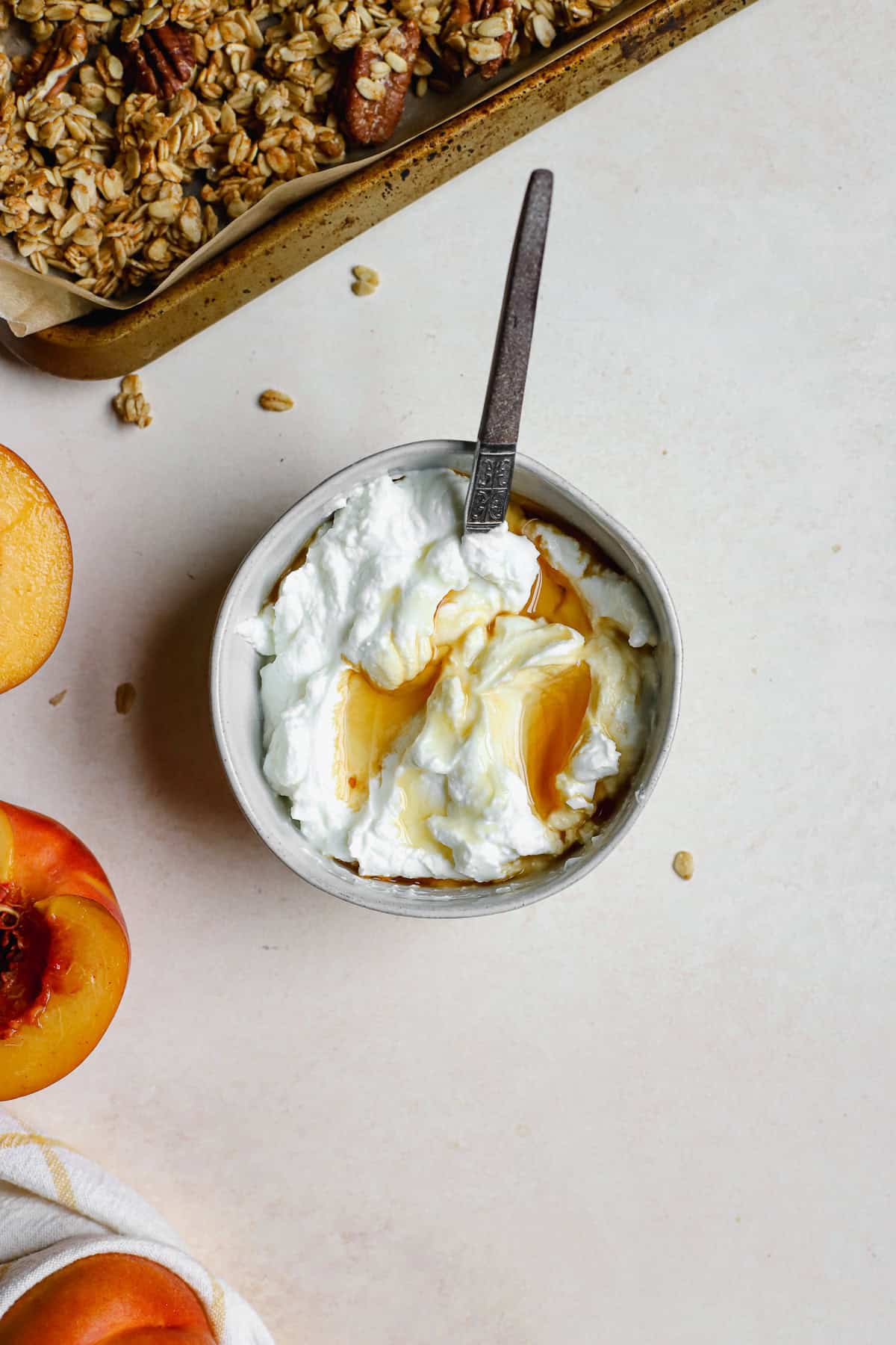 Small white bowl with Greek yogurt and maple syrup drizzled on top.