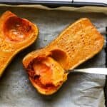 Roasted butternut squash half on sheet pan.