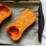 Roasted butternut squash half on sheet pan.