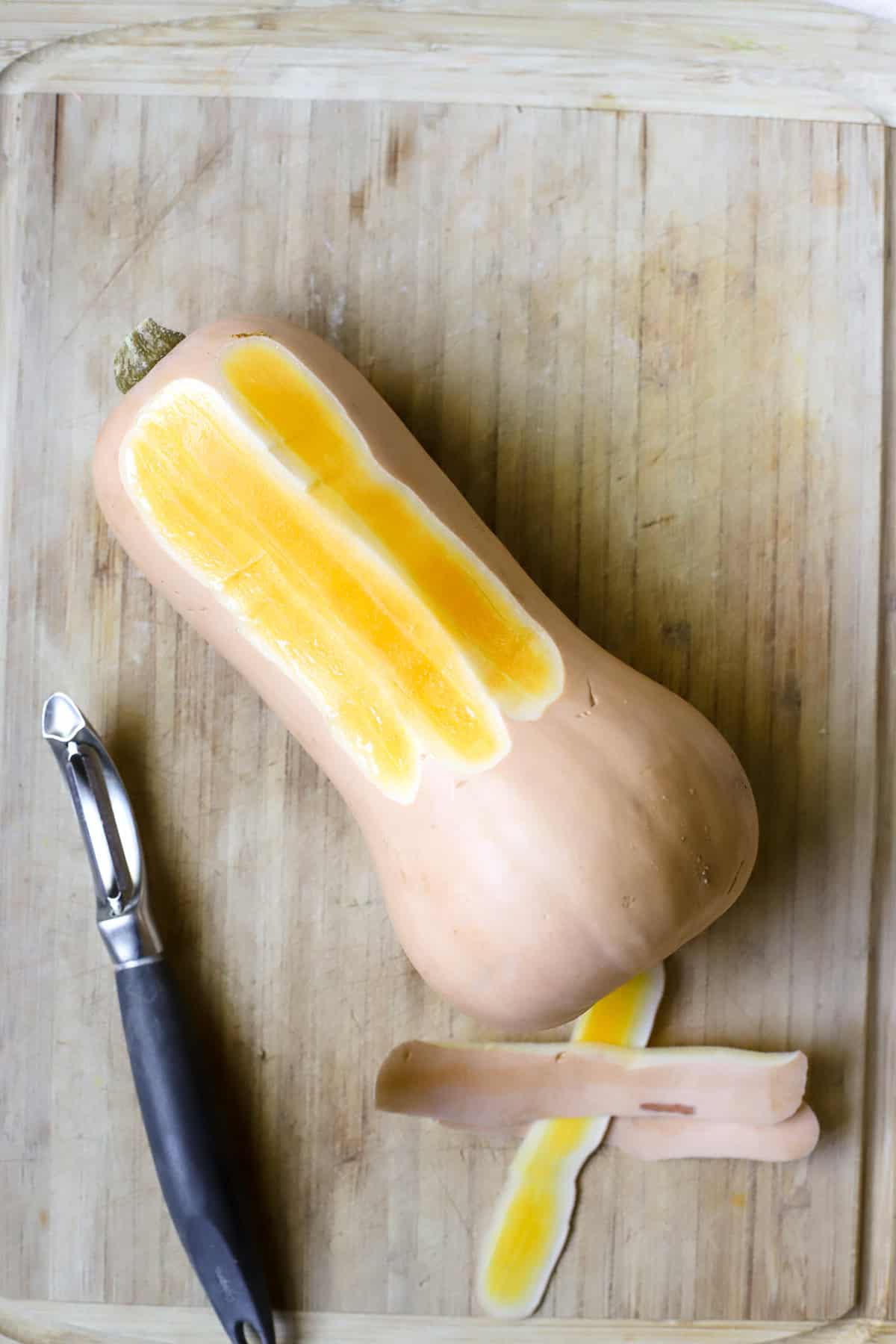 Peeling a butternut squash before roasting.