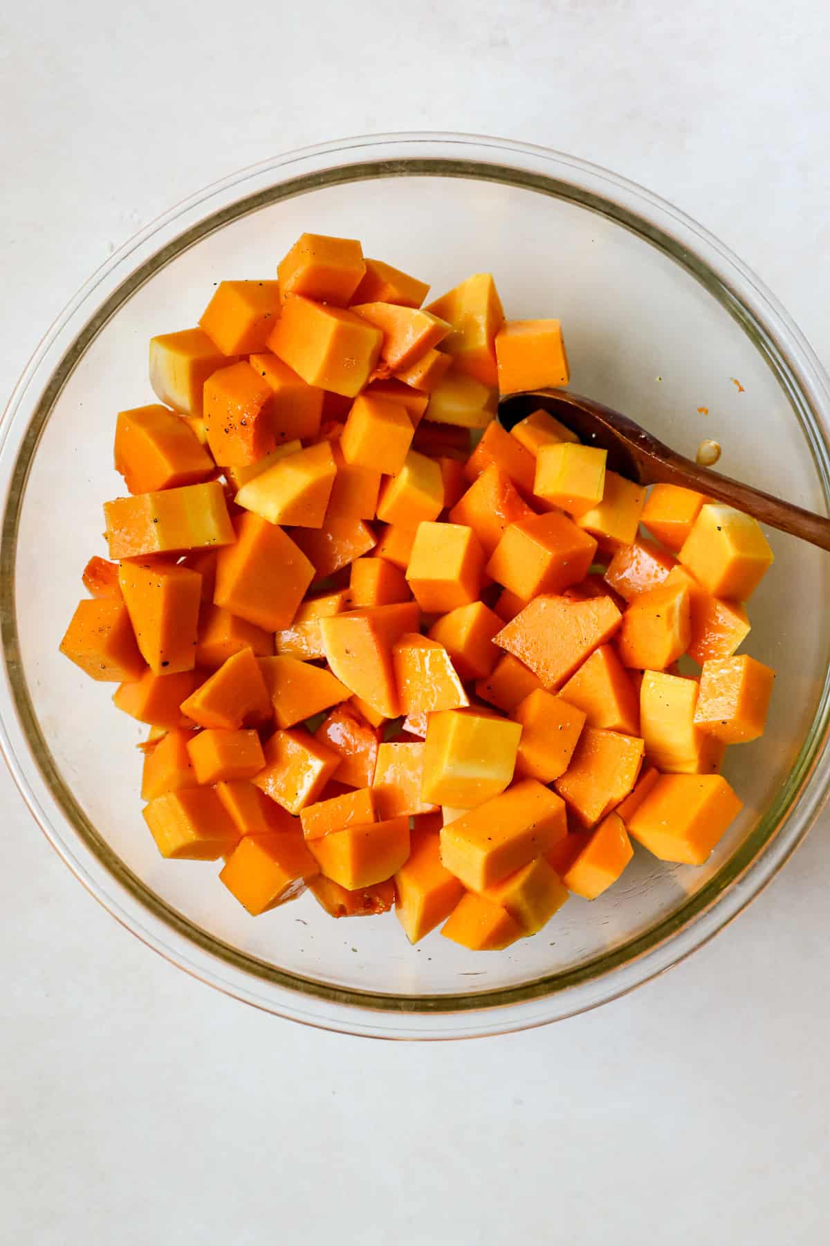 Seasoned butternut squash cubes in bowl.