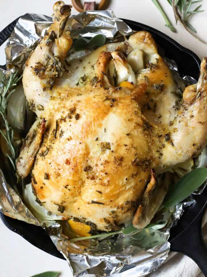 Simple roasted chicken with herbs in cast iron skillet.