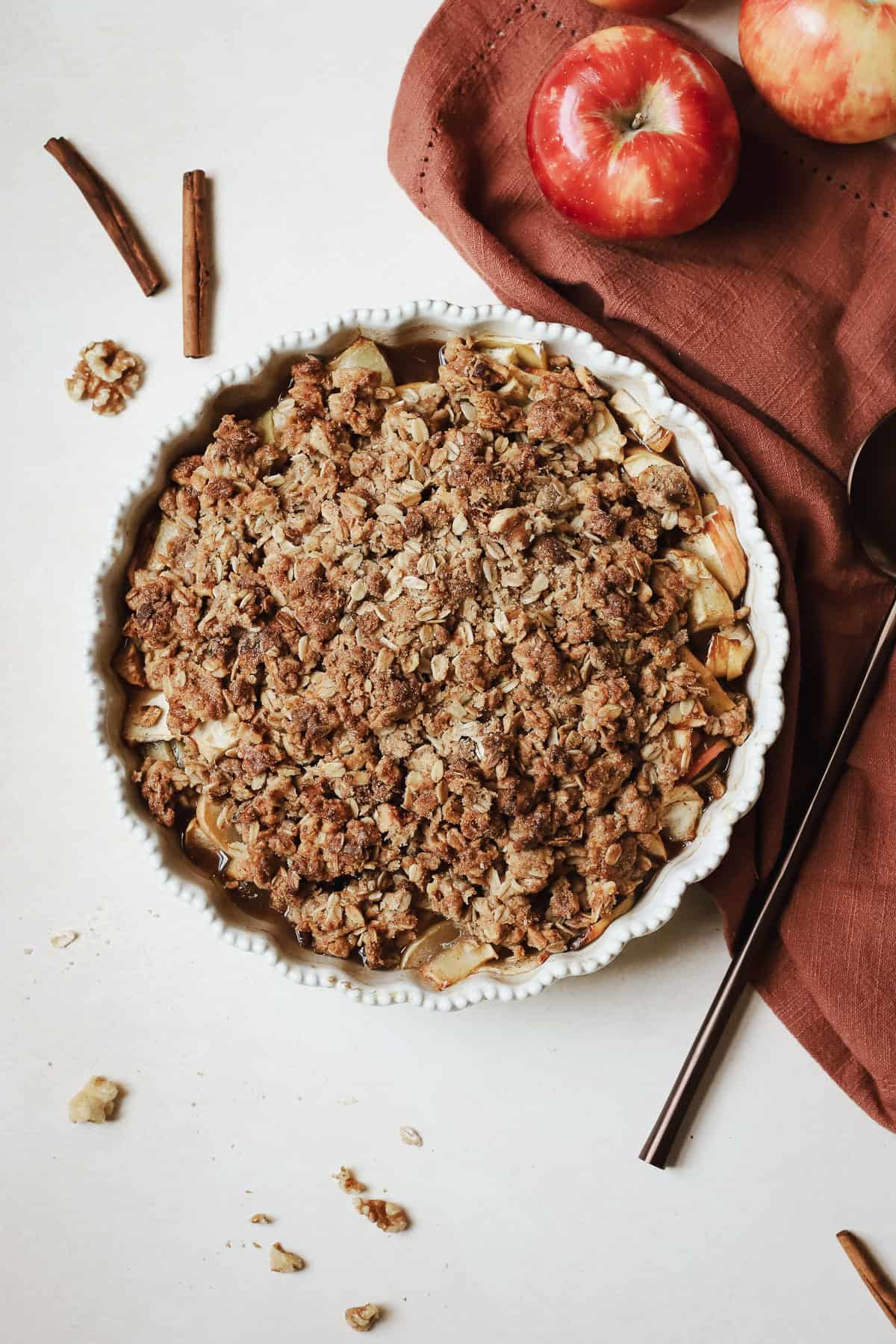 Fully baked healthy apple crisp in ceramic pie dish.