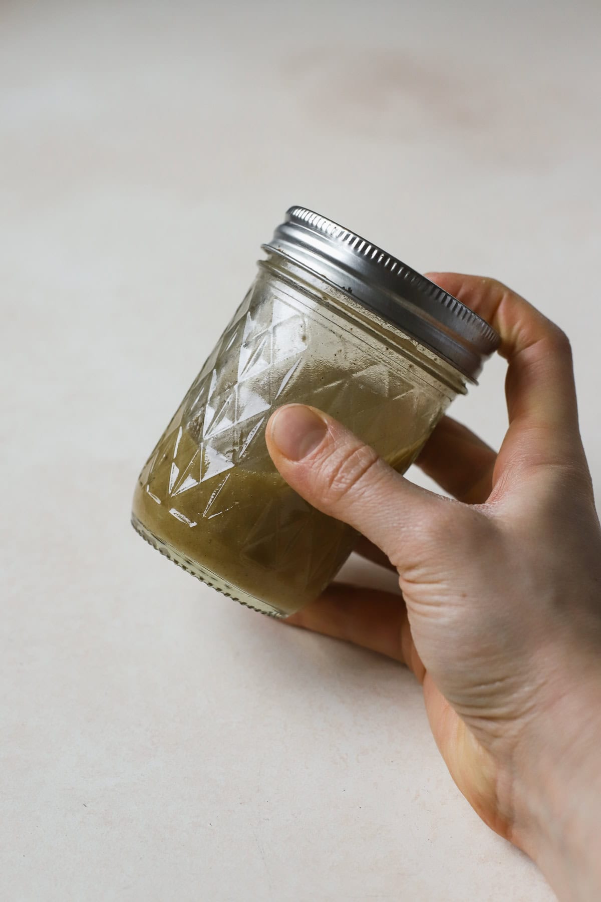 Shaking cumin orange vinaigrette together in small jar.